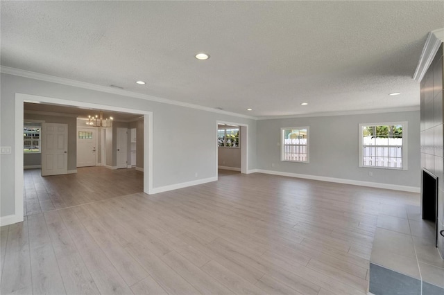 4518 Helena St NE, Saint Petersburg, FL 33703 - unfurnished living room featuring a chandelier, ornamental molding, a textured ceiling, plenty of natural light, and light wood-type flooring