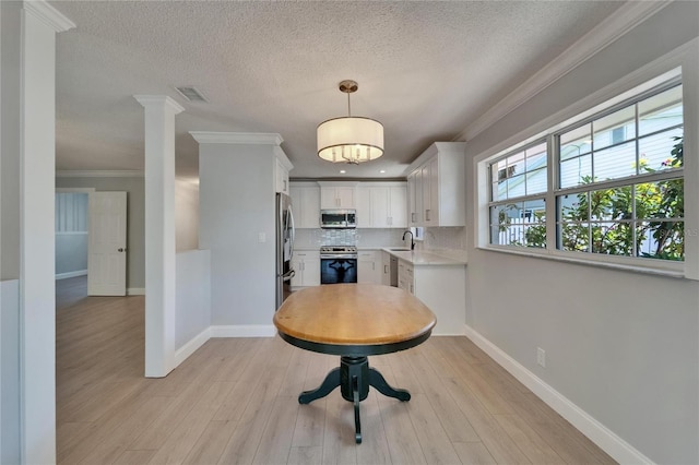 4518 Helena St NE, Saint Petersburg, FL 33703 - dining area with a textured ceiling, crown molding, light wood-style flooring, and recessed lighting