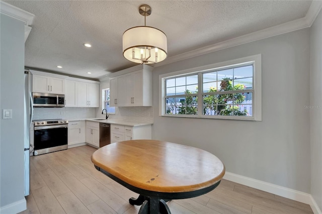 4518 Helena St NE, Saint Petersburg, FL 33703 - kitchen featuring stainless steel appliances, tasteful backsplash, light countertops, a textured ceiling, and white cabinets