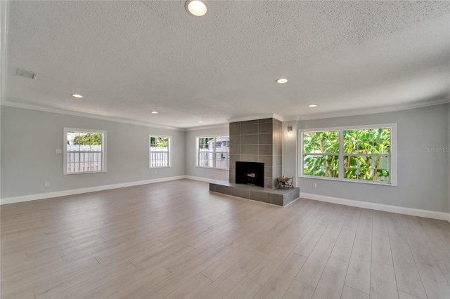 4518 Helena St NE, Saint Petersburg, FL 33703 - unfurnished living room with crown molding, a textured ceiling, a fireplace, wood finished floors, and recessed lighting