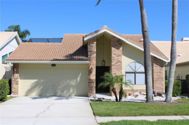 5581 Greyston St, Palm Harbor, FL 34685 - view of front facade with a garage, brick siding, concrete driveway, and a tile roof