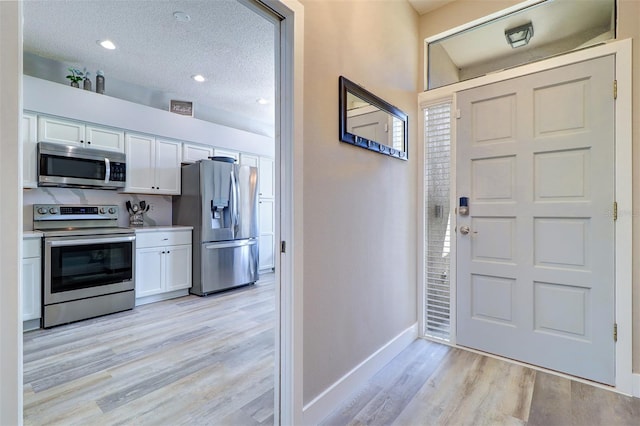 3704 Darston St, Palm Harbor, FL 34685 - entrance foyer featuring light wood-style floors and a textured ceiling
