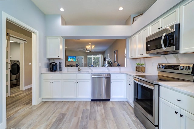 3704 Darston St, Palm Harbor, FL 34685 - kitchen with appliances with stainless steel finishes, washer / dryer, light wood-type flooring, white cabinetry, and recessed lighting