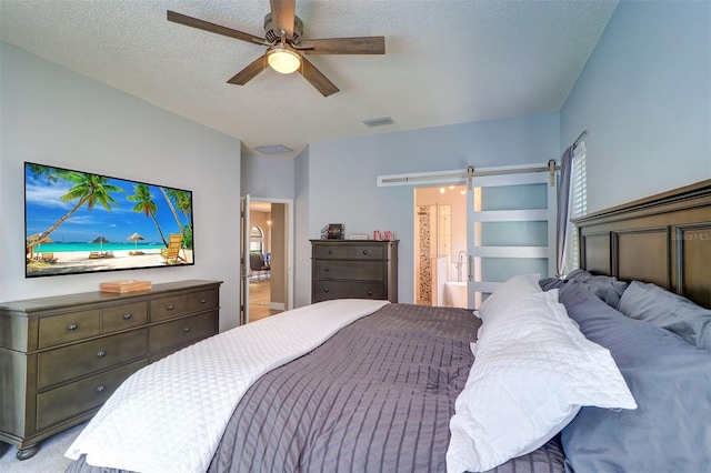 3704 Darston St, Palm Harbor, FL 34685 - bedroom featuring a barn door, a textured ceiling, ensuite bath, and ceiling fan