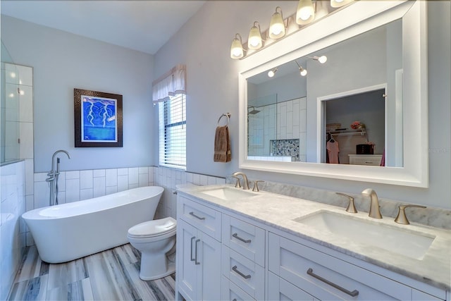 3704 Darston St, Palm Harbor, FL 34685 - full bathroom with tile walls, double vanity, a freestanding bath, a tile shower, and a walk in closet