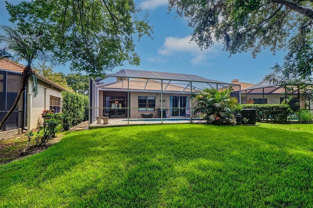 3704 Darston St, Palm Harbor, FL 34685 - rear view of property featuring a lawn, an outdoor pool, glass enclosure, and stucco siding