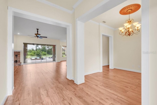 10510 Lithia Estates Dr, Lithia, FL 33547 - empty room featuring light wood finished floors, a chandelier, ornamental molding, a ceiling fan, and a fireplace