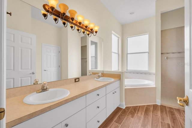 10510 Lithia Estates Dr, Lithia, FL 33547 - bathroom with a garden tub, double vanity, wood finished floors, and a tile shower