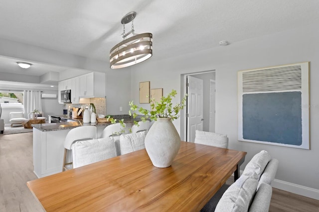 4300 Maple St NE, Saint Petersburg, FL 33703 - dining space with wood finished floors and a textured ceiling