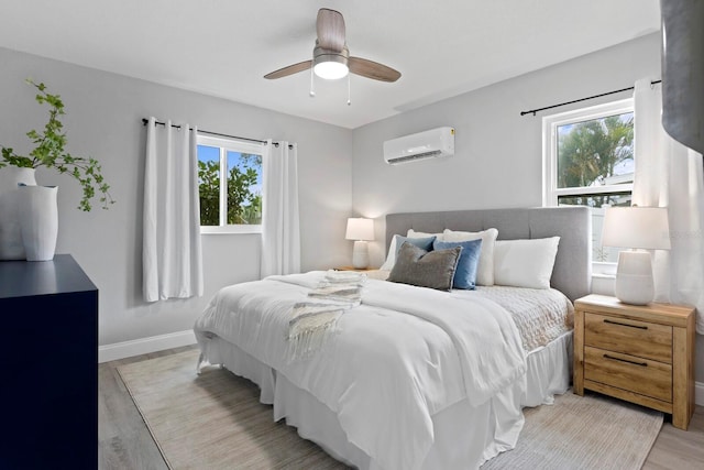 4300 Maple St NE, Saint Petersburg, FL 33703 - bedroom with a wall mounted AC, light wood-style floors, and ceiling fan