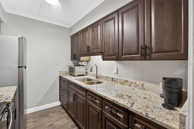 3325 Bayshore Blvd Unit A31, Tampa, FL 33629 - kitchen with crown molding, light wood-style flooring, dark brown cabinetry, stainless steel appliances, and light stone countertops