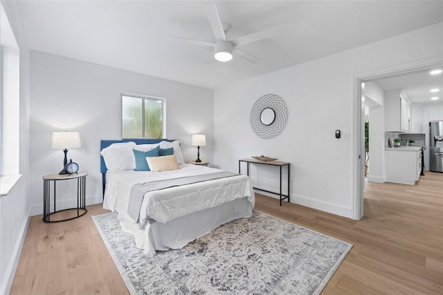 4753 58th St N, Kenneth City, FL 33709 - bedroom featuring stainless steel fridge, light wood finished floors, and a ceiling fan