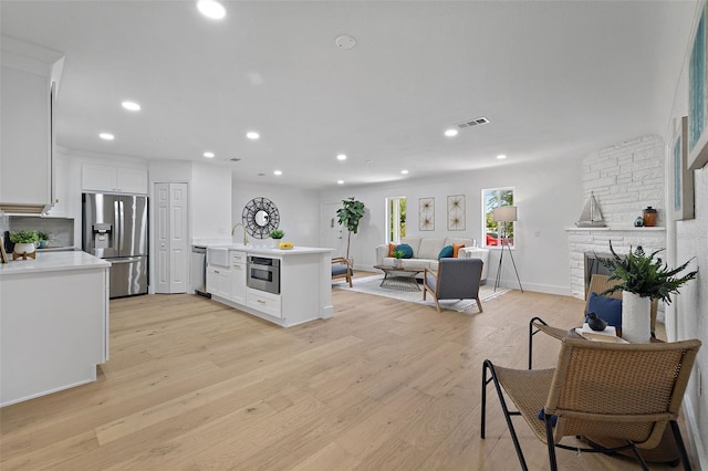 4753 58th St N, Kenneth City, FL 33709 - kitchen featuring appliances with stainless steel finishes, a peninsula, light countertops, white cabinets, and open floor plan