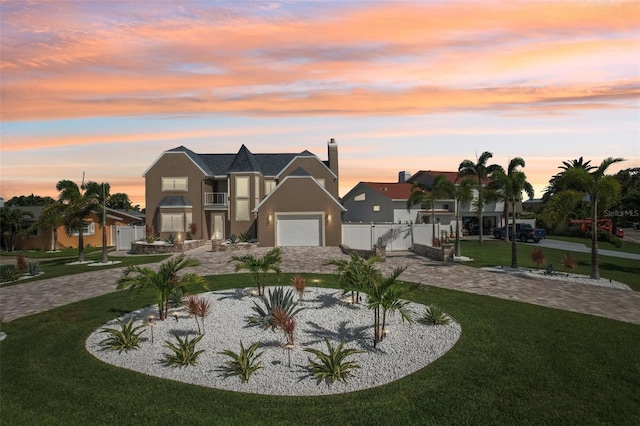 311 22nd St, Belleair Beach, FL 33786 - view of front facade with curved driveway, stucco siding, a gate, an attached garage, and a chimney