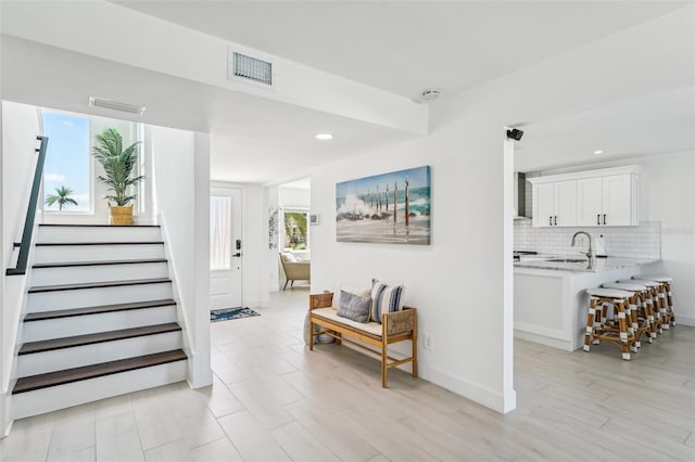 311 22nd St, Belleair Beach, FL 33786 - hallway with stairway, recessed lighting, and light wood finished floors