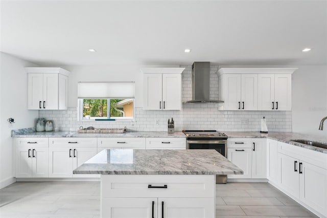 311 22nd St, Belleair Beach, FL 33786 - kitchen with wall chimney exhaust hood, tasteful backsplash, white cabinetry, light stone countertops, and recessed lighting