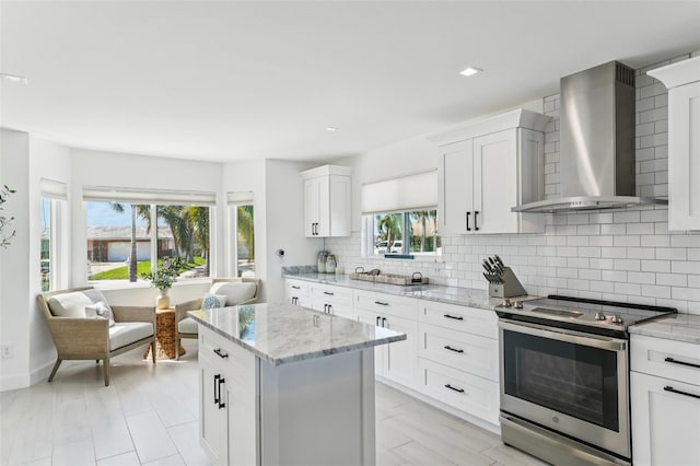 311 22nd St, Belleair Beach, FL 33786 - kitchen featuring electric range, wall chimney exhaust hood, plenty of natural light, decorative backsplash, and recessed lighting