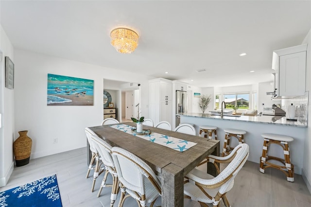 311 22nd St, Belleair Beach, FL 33786 - dining space with light wood-style flooring, recessed lighting, and a chandelier