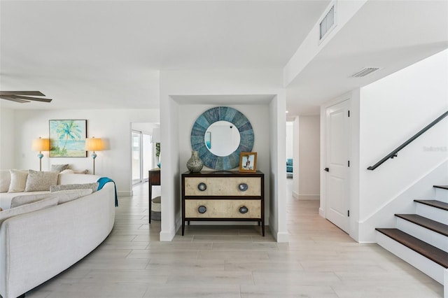311 22nd St, Belleair Beach, FL 33786 - living room featuring stairs, light wood-type flooring, and ceiling fan