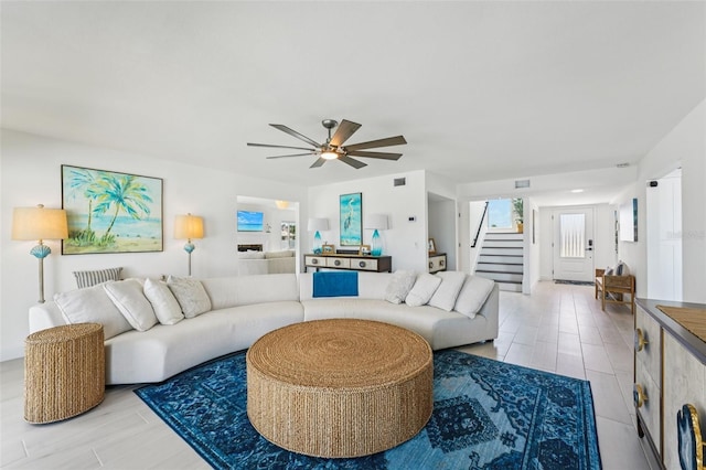 311 22nd St, Belleair Beach, FL 33786 - living room with stairway, a ceiling fan, and light wood-style flooring