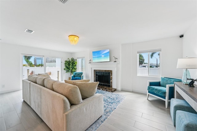 311 22nd St, Belleair Beach, FL 33786 - living area with healthy amount of natural light, a high end fireplace, and light wood-type flooring