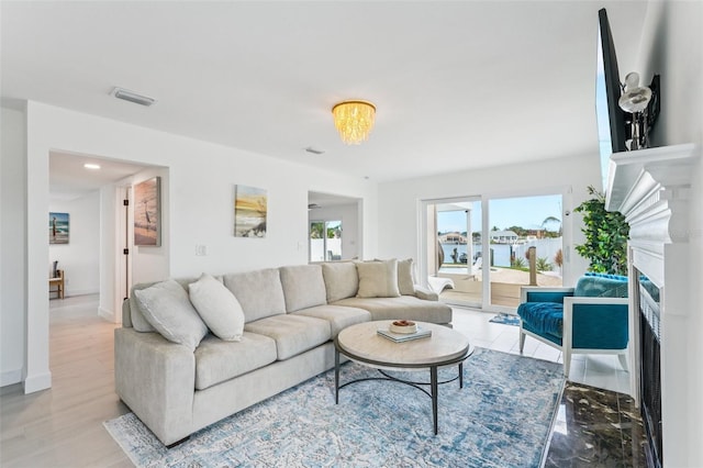 311 22nd St, Belleair Beach, FL 33786 - living room featuring a fireplace, a water view, and wood finished floors