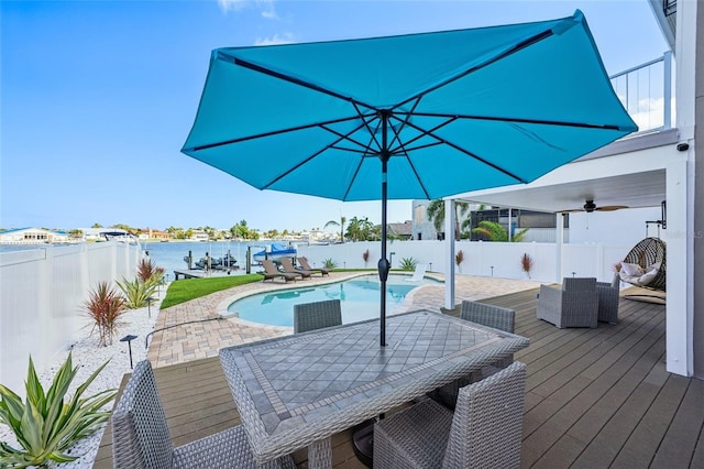 311 22nd St, Belleair Beach, FL 33786 - view of swimming pool featuring a fenced backyard, outdoor dining space, a ceiling fan, a patio area, and a deck with water view