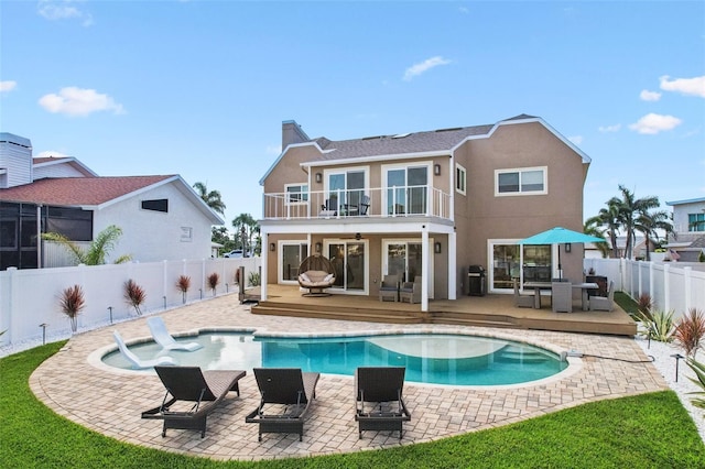 311 22nd St, Belleair Beach, FL 33786 - back of house featuring a balcony, a wooden deck, a fenced backyard, stucco siding, and a chimney