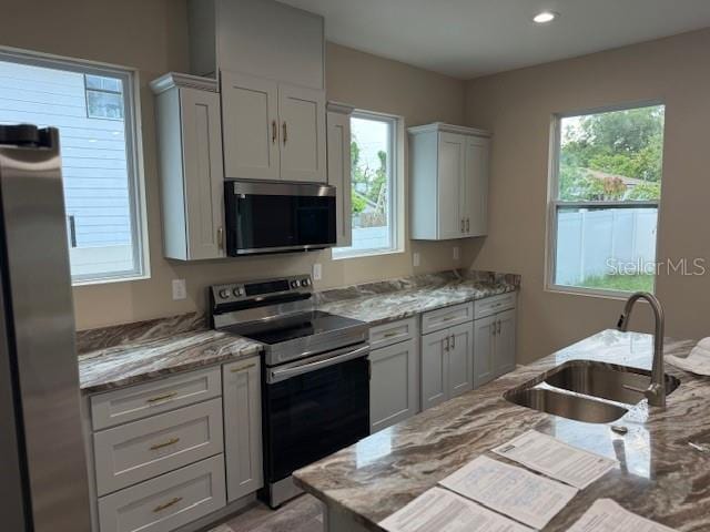 2404 Cassell St, Tampa, FL 33605 - kitchen featuring appliances with stainless steel finishes, plenty of natural light, light stone counters, and recessed lighting