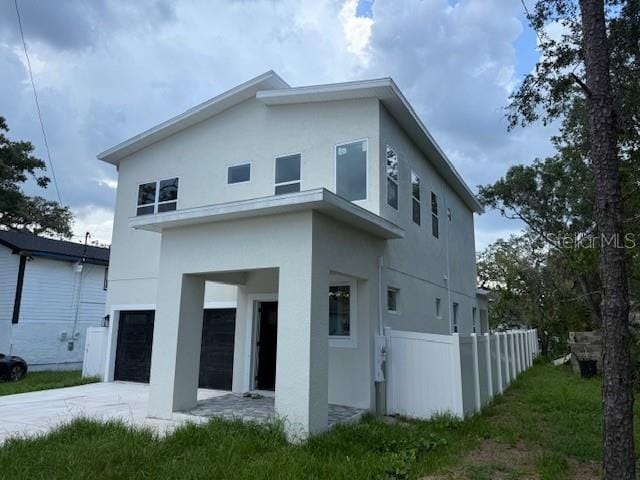 2404 Cassell St, Tampa, FL 33605 - rear view of house with stucco siding, an attached garage, and driveway
