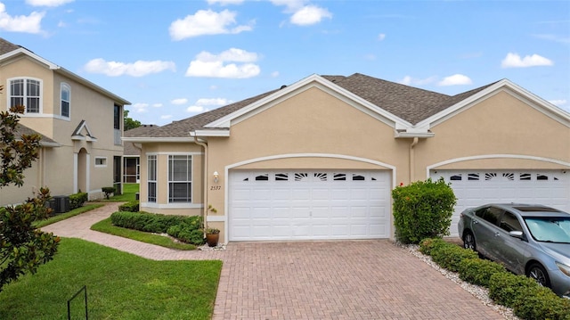 2537 Stanhope Dr, New Port Richey, FL 34655 - view of front of home featuring stucco siding, decorative driveway, a garage, and a front lawn