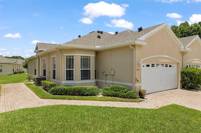 2537 Stanhope Dr, New Port Richey, FL 34655 - view of front of property with a garage, stucco siding, a front yard, roof with shingles, and decorative driveway