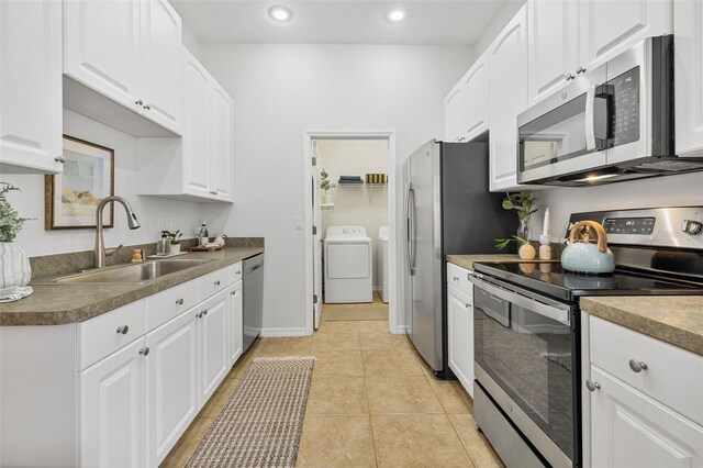 2537 Stanhope Dr, New Port Richey, FL 34655 - kitchen featuring stainless steel appliances, separate washer and dryer, white cabinetry, recessed lighting, and light tile patterned floors