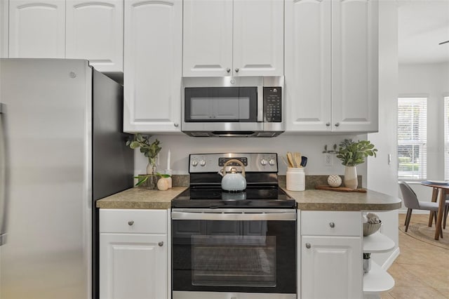 2537 Stanhope Dr, New Port Richey, FL 34655 - kitchen featuring appliances with stainless steel finishes, white cabinetry, light tile patterned floors, and open shelves