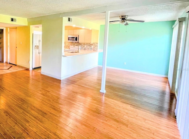 2625 State Road 590 Unit 2514, Clearwater, FL 33759 - unfurnished living room featuring a ceiling fan, light wood-style floors, and a textured ceiling