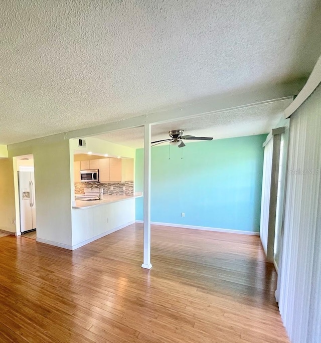 2625 State Road 590 Unit 2514, Clearwater, FL 33759 - unfurnished living room featuring a textured ceiling, a ceiling fan, and light wood-style flooring