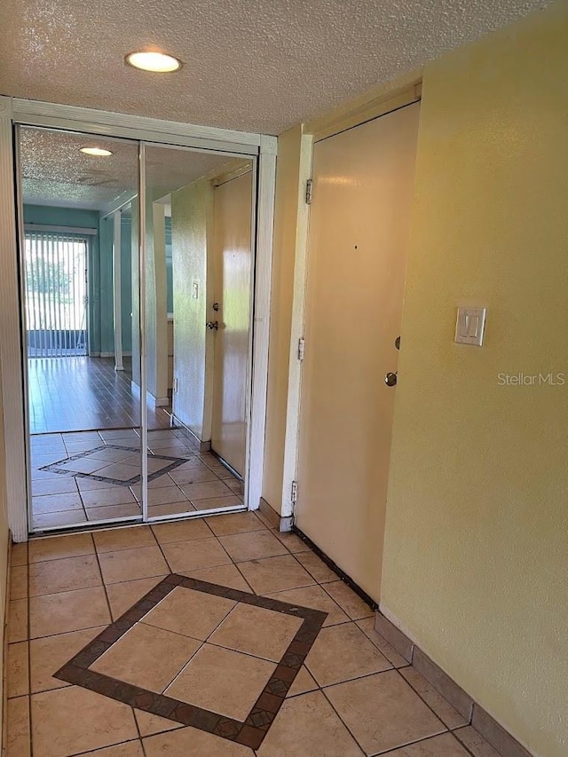 2625 State Road 590 Unit 2514, Clearwater, FL 33759 - corridor with a textured ceiling, light tile patterned floors, and inlaid floor details