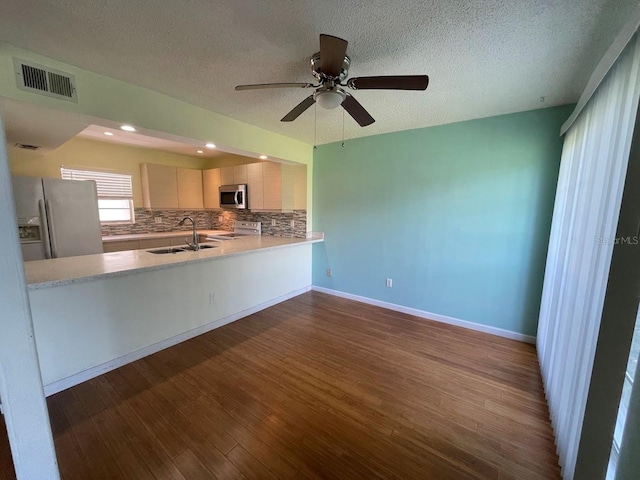2625 State Road 590 Unit 2514, Clearwater, FL 33759 - kitchen with white appliances, dark wood finished floors, tasteful backsplash, light countertops, and a ceiling fan