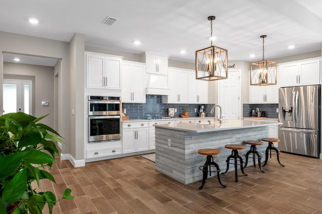 11714 Tetrafin Dr, Riverview, FL 33579 - kitchen with stainless steel appliances, light countertops, a kitchen bar, tasteful backsplash, and an island with sink