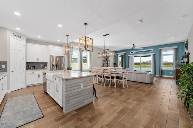 11714 Tetrafin Dr, Riverview, FL 33579 - kitchen with appliances with stainless steel finishes, open floor plan, light countertops, backsplash, and white cabinets