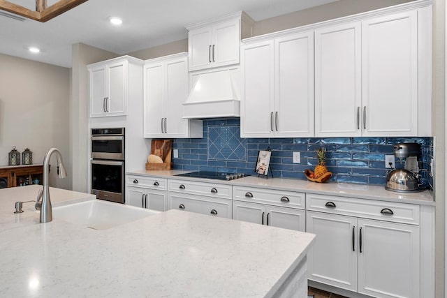 11714 Tetrafin Dr, Riverview, FL 33579 - kitchen featuring stainless steel double oven, white cabinets, tasteful backsplash, custom exhaust hood, and recessed lighting