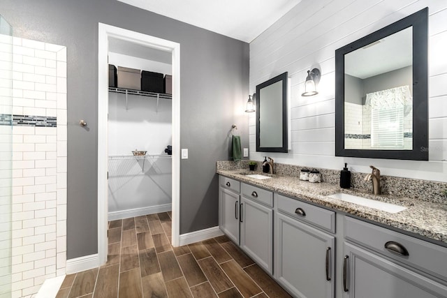 11714 Tetrafin Dr, Riverview, FL 33579 - bathroom featuring double vanity, wood finished floors, a walk in closet, and tiled shower