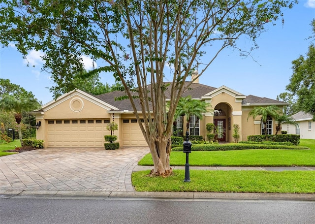 12439 Bristol Commons Cir, Tampa, FL 33626 - view of front of property with stucco siding, an attached garage, a front yard, decorative driveway, and a chimney