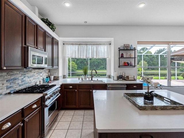 12439 Bristol Commons Cir, Tampa, FL 33626 - kitchen with stainless steel appliances, plenty of natural light, light tile patterned floors, recessed lighting, and dark brown cabinetry