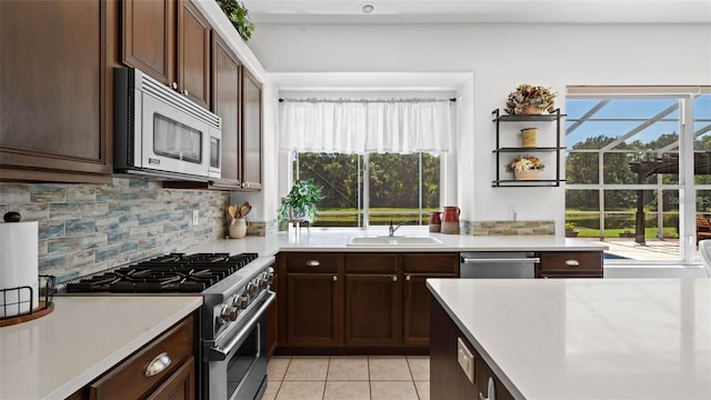 12439 Bristol Commons Cir, Tampa, FL 33626 - kitchen featuring appliances with stainless steel finishes, light tile patterned floors, light countertops, decorative backsplash, and dark brown cabinets