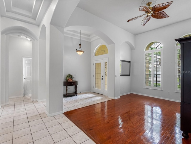 12439 Bristol Commons Cir, Tampa, FL 33626 - entrance foyer featuring ceiling fan, light tile patterned floors, arched walkways, and a towering ceiling