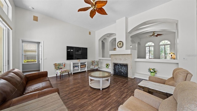 12439 Bristol Commons Cir, Tampa, FL 33626 - living area with ceiling fan, built in features, wood finished floors, a tiled fireplace, and arched walkways