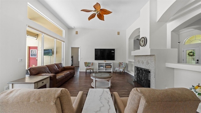 12439 Bristol Commons Cir, Tampa, FL 33626 - living room with ceiling fan, dark wood-style floors, a fireplace, arched walkways, and built in features