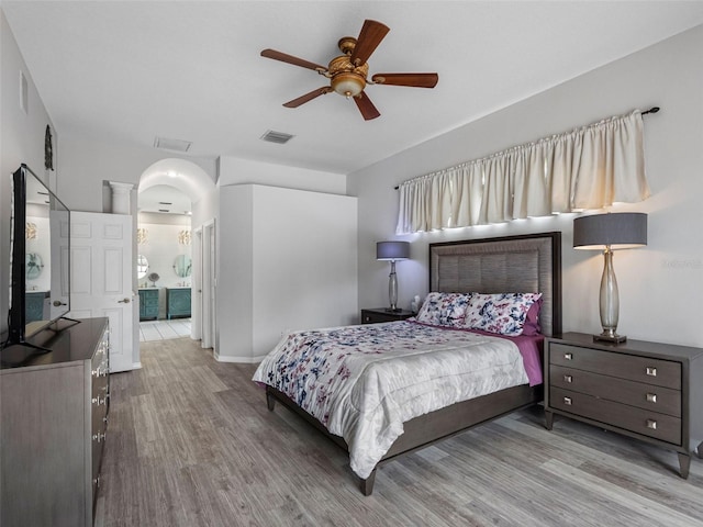 12439 Bristol Commons Cir, Tampa, FL 33626 - bedroom with wood finished floors, ceiling fan, arched walkways, and connected bathroom