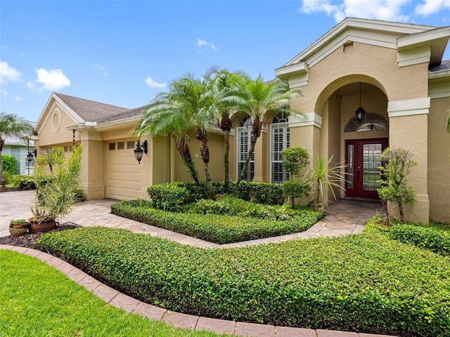 12439 Bristol Commons Cir, Tampa, FL 33626 - view of front of home with stucco siding, an attached garage, and french doors